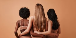 women holding each other's waist facing wall