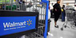 Shoppers wait in line to pay for their purchases at a Walmart.