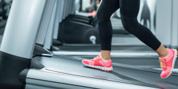 Person wearing pink shoes walking on an inclined treadmill