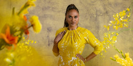 Ava DuVernay poses for a photograph among yellow flowers on a set
