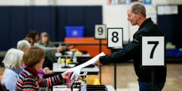 A voter is handed his ballot by an election worker
