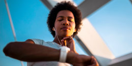 Woman checking heart rate after sports training on bridge in morning time