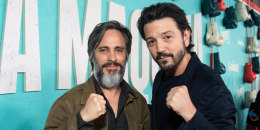 Gael Garcia Bernal, left, and Diego Luna pose for a photo together on the red carpet, holding up their fists