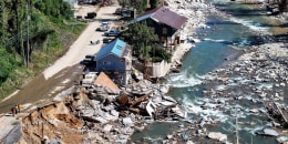 An aerial view of damaged housing near a river