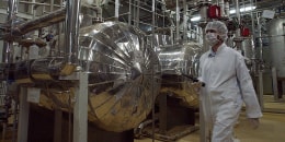 A security official in protective clothing walks inside a facility