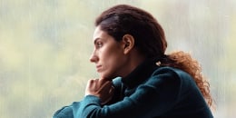 Side view thoughtful, sad woman looking out rainy window.