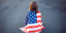 Sad lonely patriot woman sitting down with the american flag