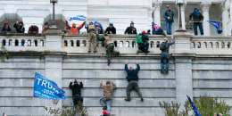 Trump supporters climb the west wall of the the Capitol