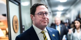 Mike Flood inside of a hallway with other people walking behind him