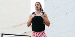 Woman doing squats wearing weighted vest