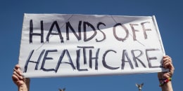 Brenda Patoine holds a sign that reads "Hands off Healthcare"