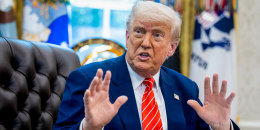 Donald Trump speaks while seated at his desk in the Oval Office