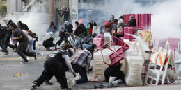 Police fire tear gas and break through a barricade