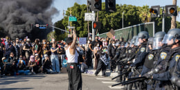 A protester in front of a police line 