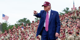 Donald Trump points while on stage outside