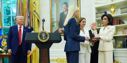 Jeanine Pirro raises her hand during a swearing-in ceremony as President Trump looks on.