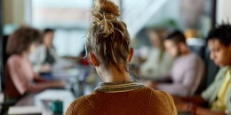 Back view of creative woman on a meeting in the office.