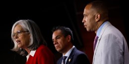 Katherine Clark speaks with Pete Aguilar and Hakeem Jeffries standing behind her during a news conference.