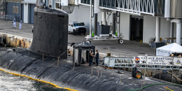 US Navy personnel stand a top USS New Hampshire.