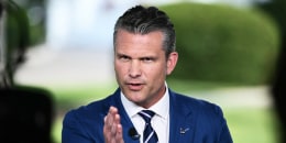 Pete Hegseth gestures during a television interview 