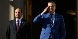 Qatari Defense Minister Sheikh Saoud Al Thani stands next to Pete Hegseth at the Pentagon. Hegseth salutes.