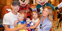 Christopher French, left, Ashley Tisdale, and two little girls pose with Minnie and Mickey Mouse