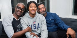 Charone Gray-Edwards, left, Laila Edwards, and Robert Edwards sit together on a couch and pose for a photo