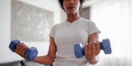 Woman exercising at home with dumbbells