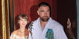 Travis Kelce, looking toward the camera, holds Taylor Swift's hand as they exit a building to the street.