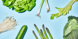 Different sorts of green vegetable on blue background