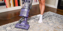 Woman using a vacuum on a carpet