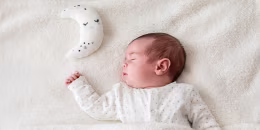 Baby boy in bed sleeping with moon