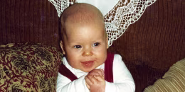 Baby boy back in the eighties sitting on sofa.
