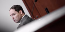 A tilted view of Brendan Banfield, seated in a courtroom.