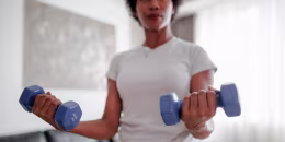 Woman exercising at home with dumbbells