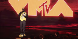 Snoop Dogg on stage in front of a giant VMA backdrop.