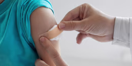 Unrecognizable doctor putting a patch on shoulder after successful vaccination