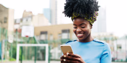 Woman using smart phone in city