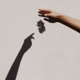 Cropped Hands Of People Against Gray Wall