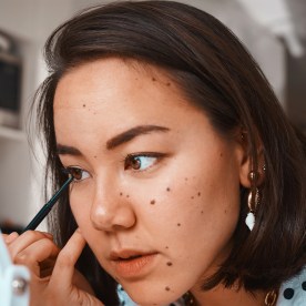 Woman putting on eyeliner