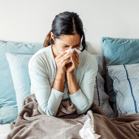 Woman with flu in bed, she use home medicine to handle sickness