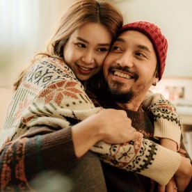 Happy young couple relaxing in warm clothing during winter.