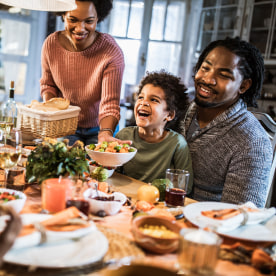 Happy African American family enjoying in Thanksgiving dinner at home.