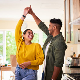 Shot of a young couple dancing together in their kitchen