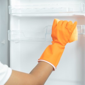Cropped Hand Of Woman Cleaning Refrigerator