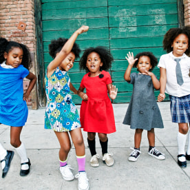 Girls dancing on city sidewalk