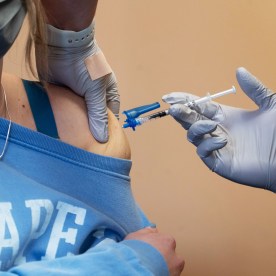 A healthcare worker administers a dose of the Pfizer-BioNTech Covid-19 vaccine at a vaccination clinic in the Peabody Institute Library in Peabody, Massachusetts, U.S., on Wednesday, Jan. 26, 2022.
