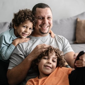 Father and sons watching TV at home