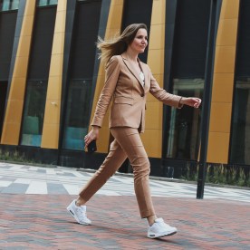 Mid Adult Businesswoman Wearing Beige Pantsuit Walking Fast Next Modern Office Buildings