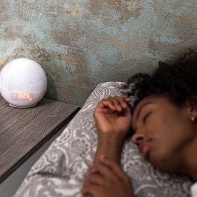 Alarm clock near sleeping woman